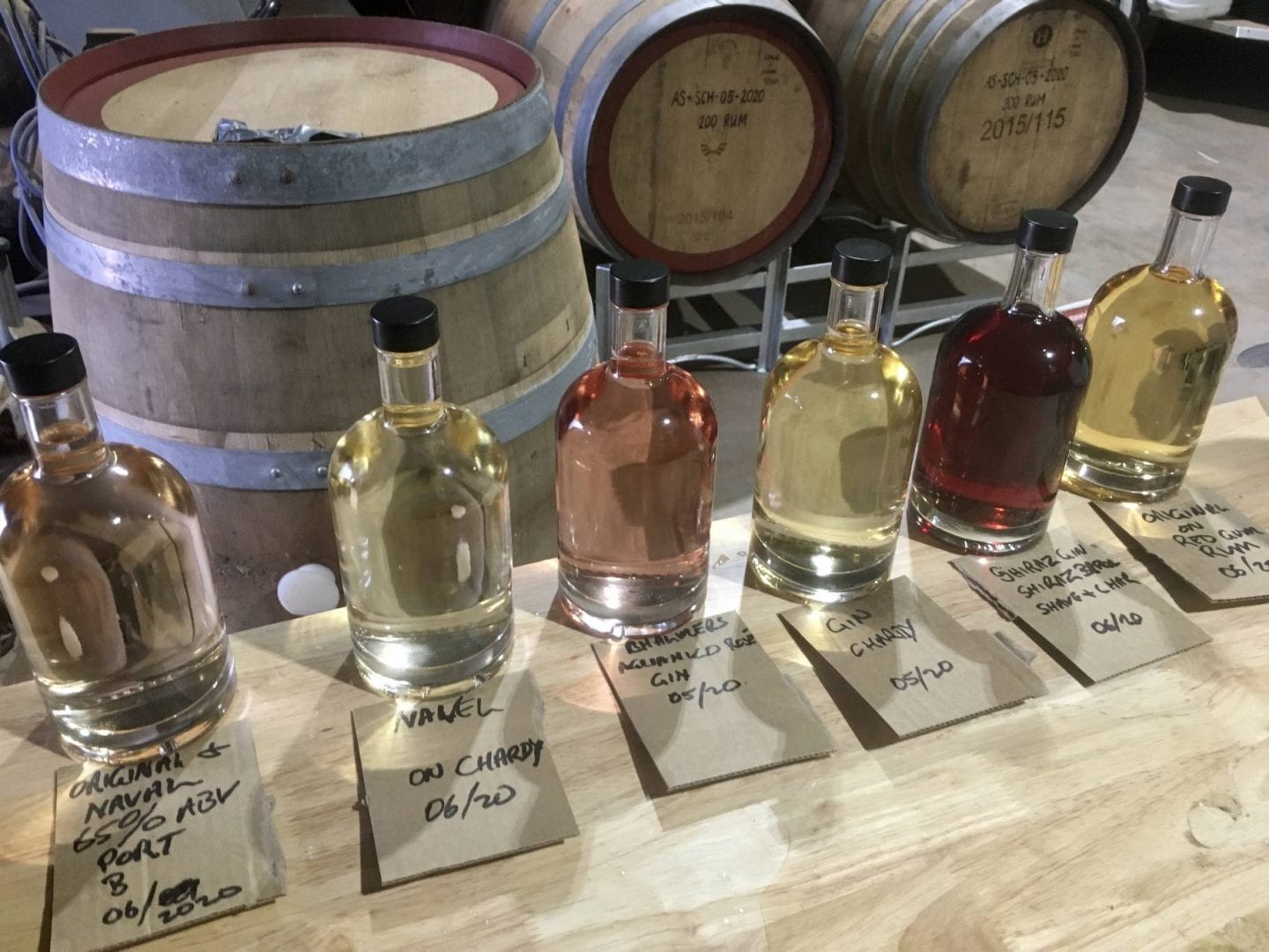 unlabled gins on bench with barrels